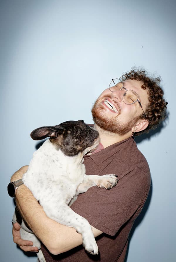 chien dans les bras de son maitre qui rigole