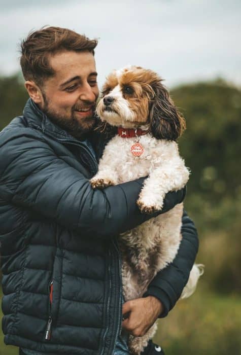 chien pensif dans les bras de son maitre très heureux et souriant