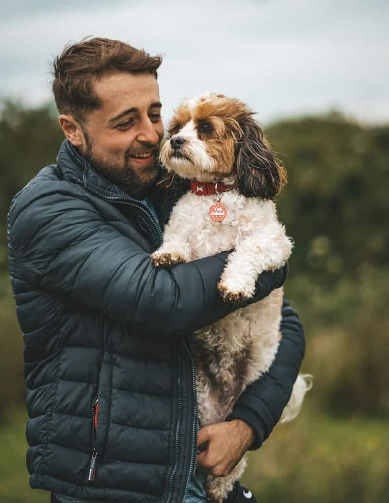 chien pensif dans les bras de son maitre très heureux et souriant