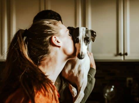 Femme qui aime son chien et le prend dans ses bras pour lui faire un câlin