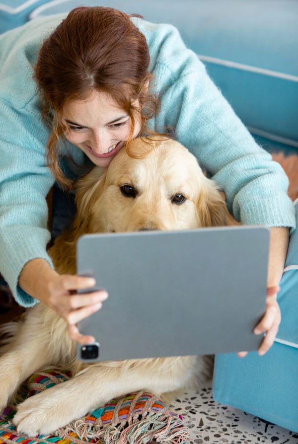 Chien avec son propriétaire devant un ordinateur