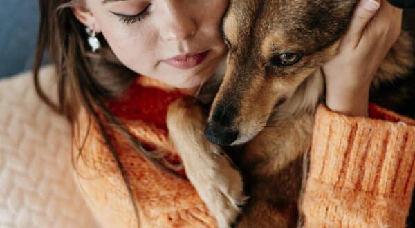 Humaine et son chien qui font un câlin