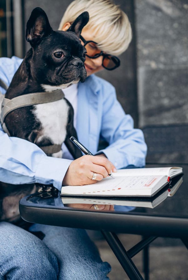 Chien avec sa propriétaire qui fait ses comptes
