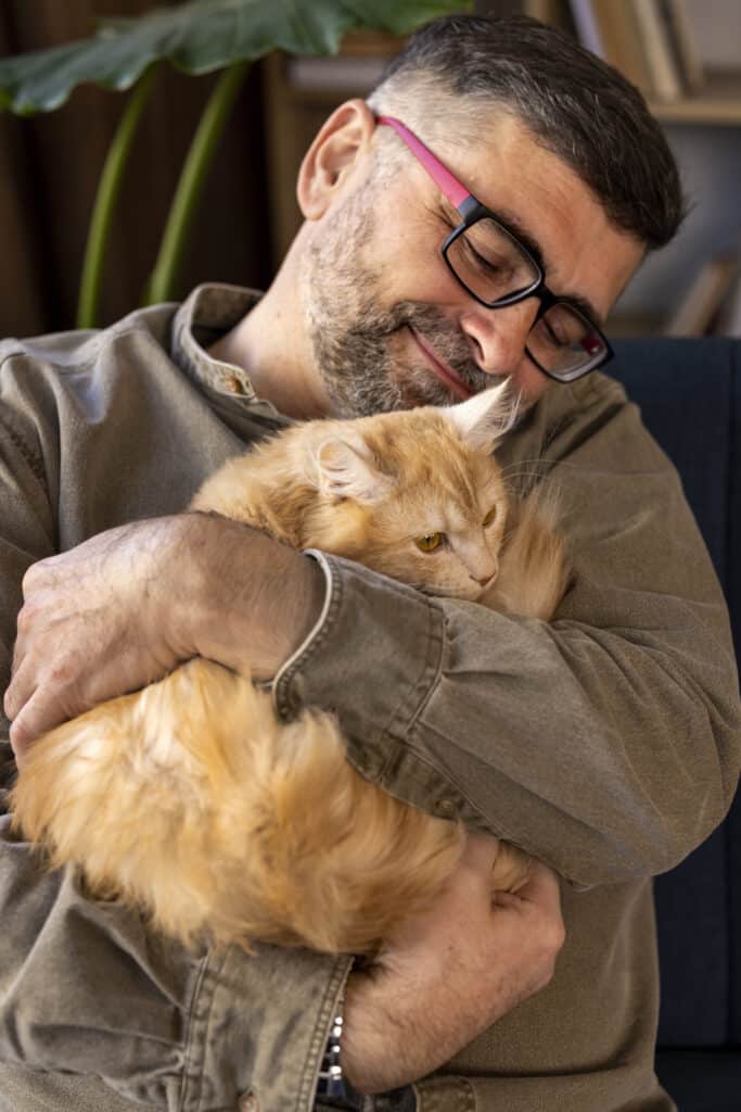Homme et chat qui font un câlin