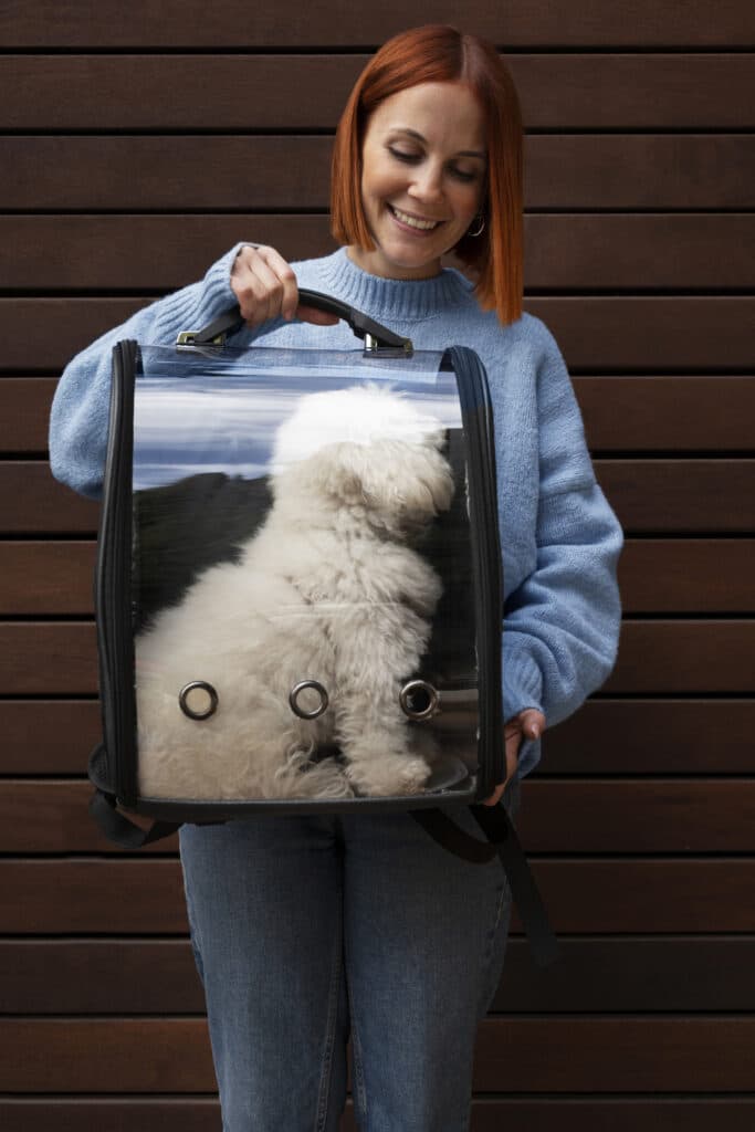 Femme qui porte son chien dans un sac de transport