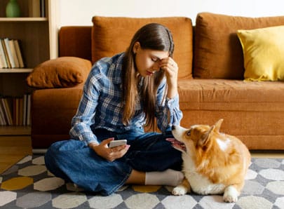 une femme sur son téléphone triste avec son chien