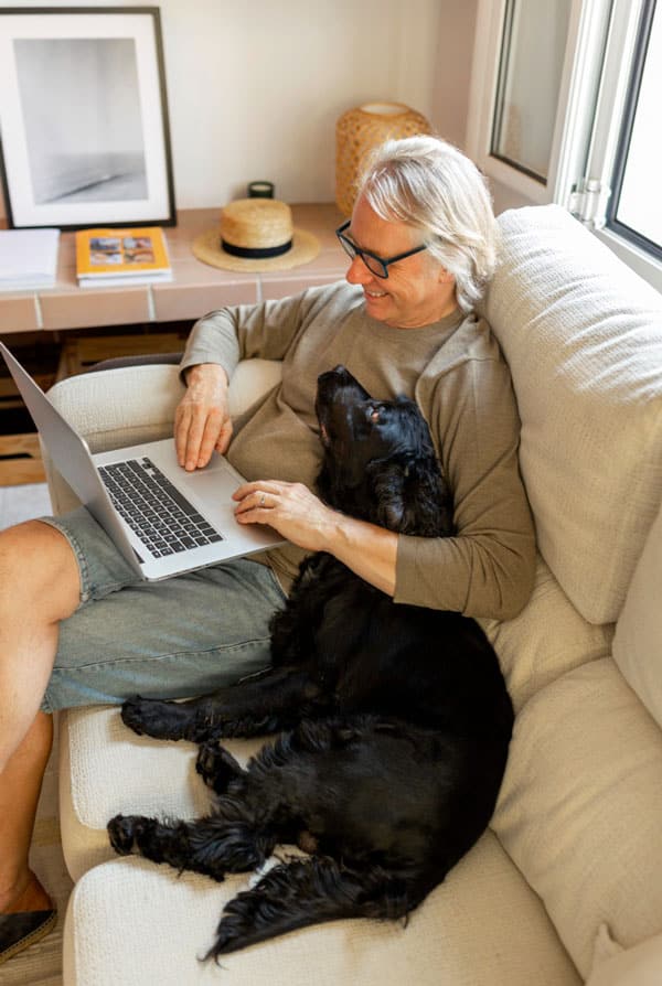 un chien noir dans les bras de son propriétaire dans le canape