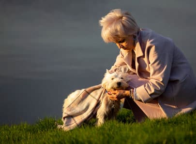 Un chien aveugle avec sa propriétaire devant un lac