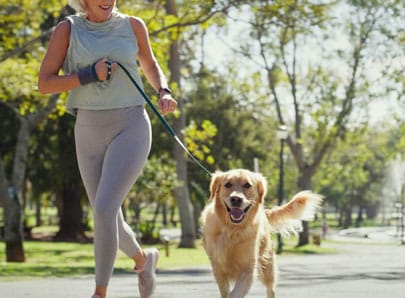 Un chien qui court avec sa propriétaire